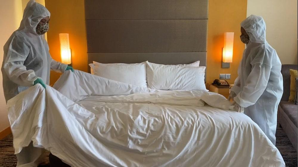 The Waterfront Hotel Kuching Eksteriør billede Housekeeping staff making a bed